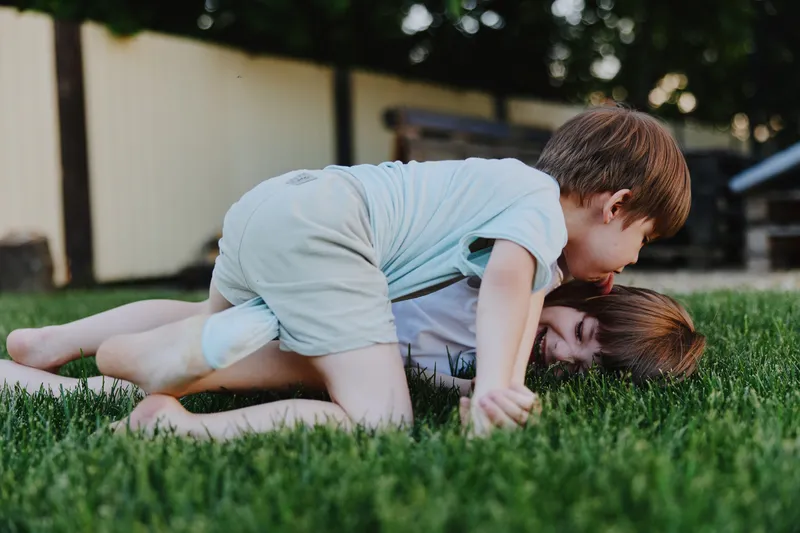 Playing children enjoying fun outdoors, showing joy and friendship in a vibrant green setting, capturing the essence of childhood playfulness and connection.