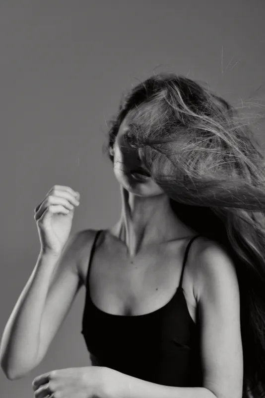 Black and white portrait of a woman with flowing hair and natural expression