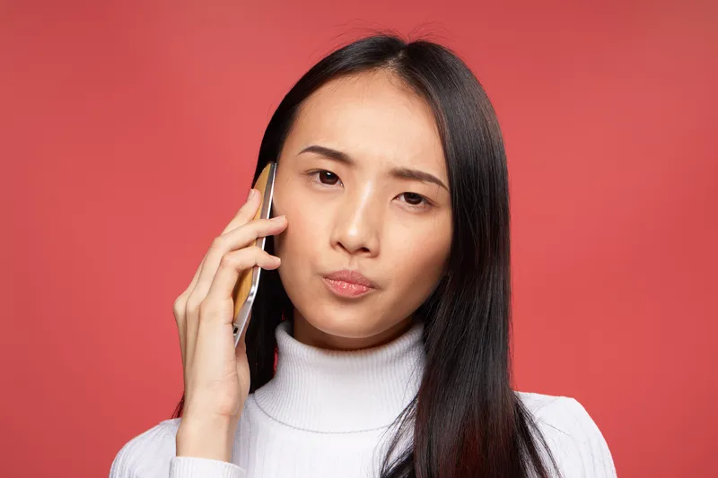 Симпатичная женщина азиатской внешности разговаривает по телефону
