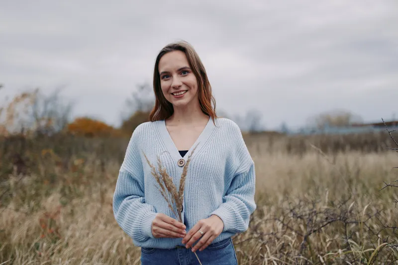 Authentic portrait in a natural field setting with a candid moment, soft light, and a calm atmosphere that highlights real life and genuine emotion.