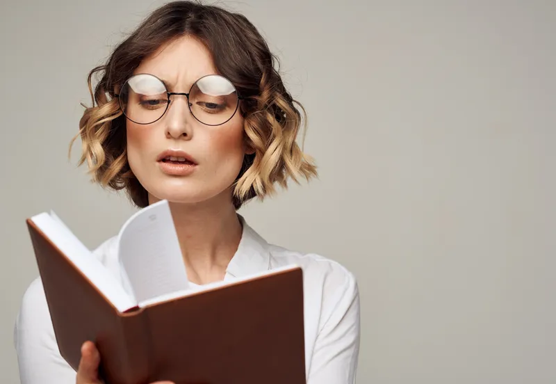 Образованная женщина с книгой в руках, в очках и белой рубашке, образовательная модель