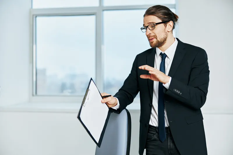 Бизнесмен в костюме работает по телефону в офисе