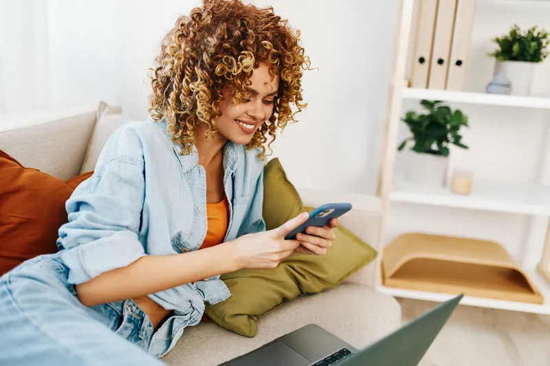 Современный образ жизни: улыбающаяся женщина работает за ноутбуком в уютном домашнем офисе