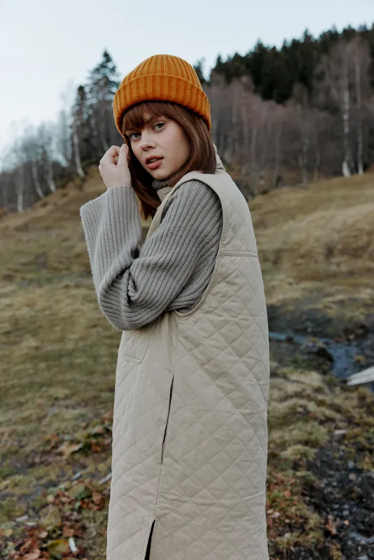 Молодая женщина гуляет по осеннему лесу, наслаждаясь свежим воздухом, путешествием и пейзажем