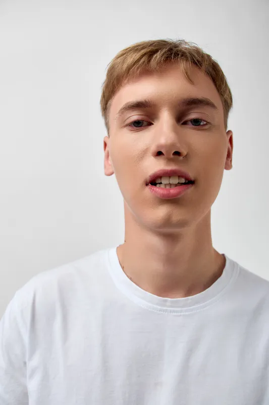 Young man close up, white shirt, calm face, studio lighting and clean background, ideal for fashion, lifestyle, technology, and corporate stock photography