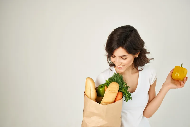 Брюнетка с пакетом продуктов, доставка из супермаркета