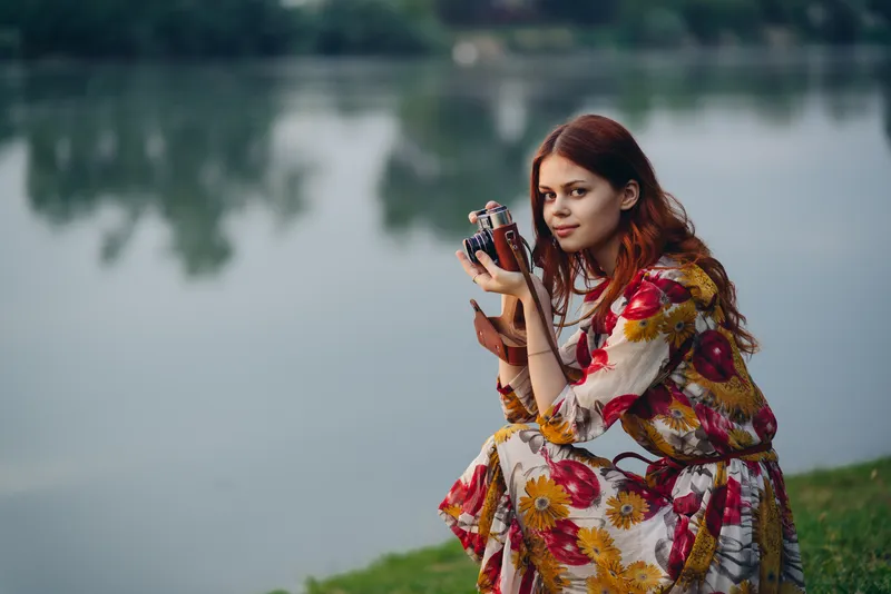 Женщина с фотоаппаратом на природе у реки, отдых, путешествие