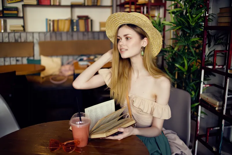Красивая женщина с книгой в руках в кафе, образ жизни