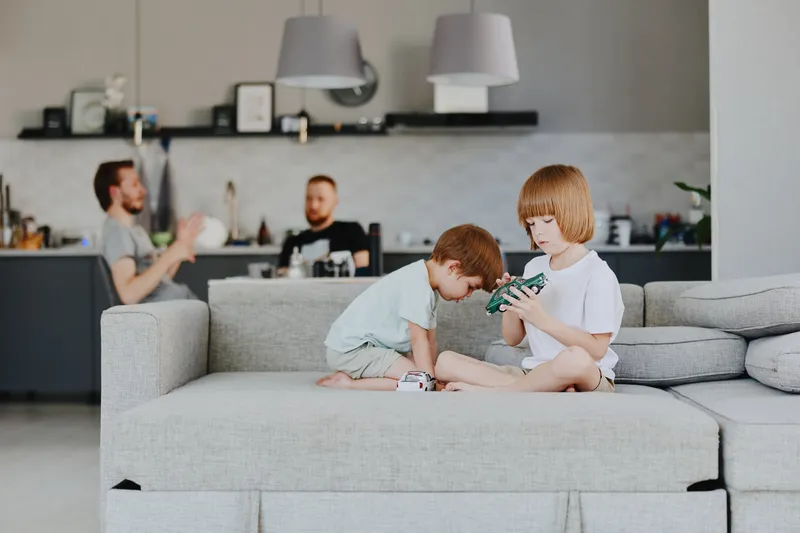 Two young boys playing with toys in a cozy living room. Their curiosity and happiness fill the space, creating a warm family atmosphere.