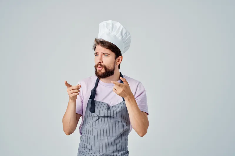 Мужчина в фартуке, работа на кухне, профессиональное обслуживание