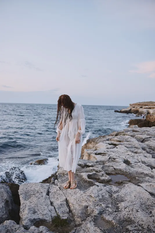 Женщина-путешественница в белом платье стоит на природе на открытом воздухе
