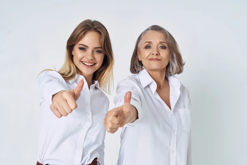 Внучка обнимает бабушку, вокруг царит веселье, семейная любовь