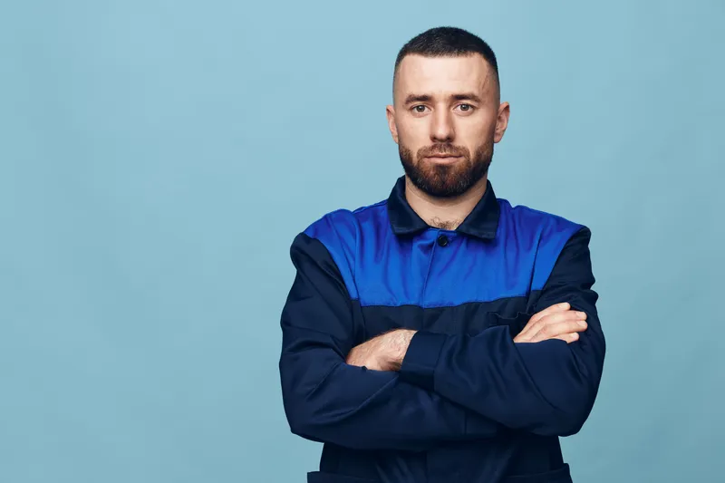 Мужчина с бородой стоит на изолированном фоне, его лицо выражает уверенность и серьезность