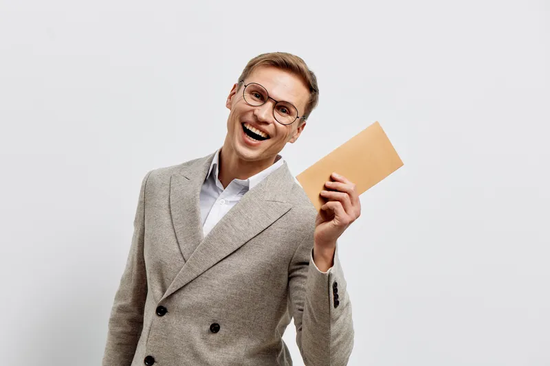 happy man holding envelope smiling in beige jacket isolated on plain light background digital detox concept emotion communication