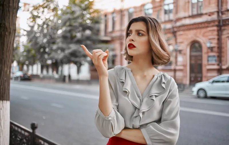 Красивая блондинка идет по улице рядом с историческими зданиями на природе