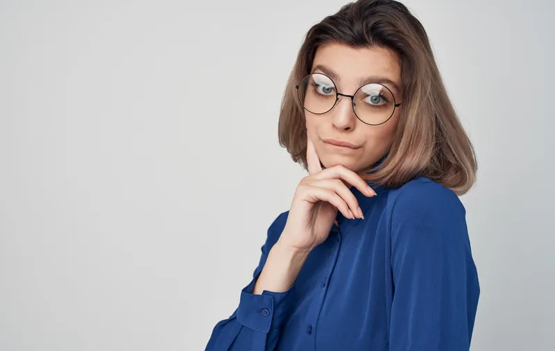 Деловая женщина в синей рубашке на официальном изолированном фоне в офисе
