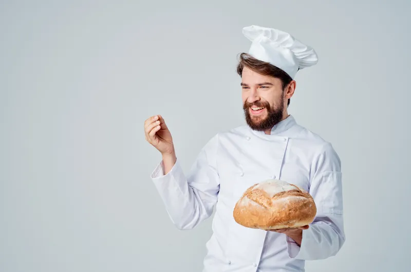 Бородатый мужчина-повар, кухонная работа, хлебобулочные изделия, профессиональные эмоции