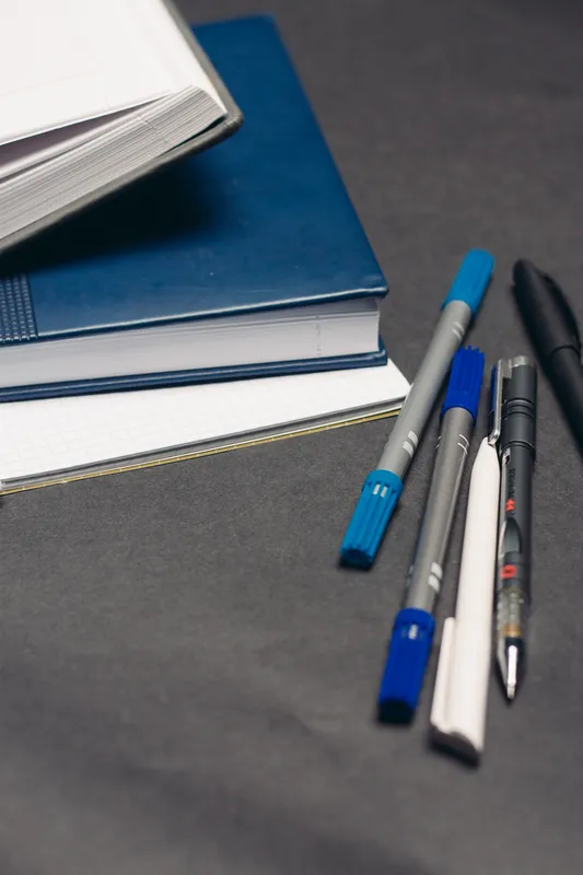 Блокноты, документы, книги, ручки на рабочем столе, серый фон, офис