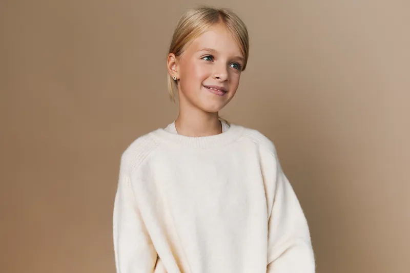 Authentic portrayal of a young student in a cozy sweater, capturing a candid moment of playful learning and everyday school life with a warm, natural vibe.