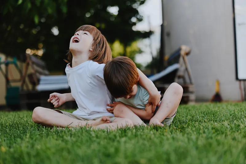 Joyful children playing outdoors, laughing and having fun together in a sunny garden. Their innocence and energy are captivating and heartwarming moments.