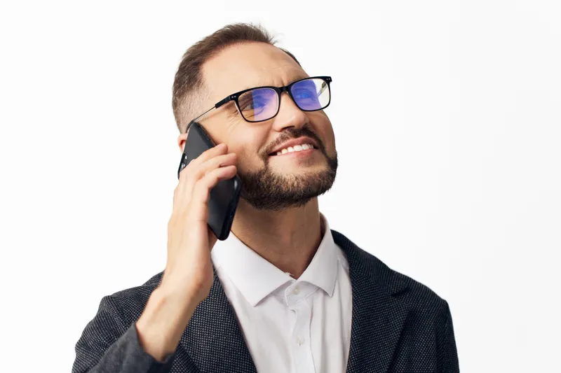 A confident business professional on a colored isolated background, smiling while on a phone call, conveying engagement, communication, and success in a dynamic work moment.