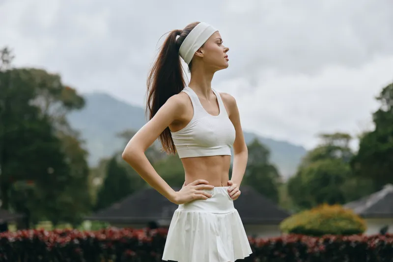 Athletic young woman in sporty outfit, showcasing confidence and fitness against a natural background, perfect for healthy lifestyle and sports themes