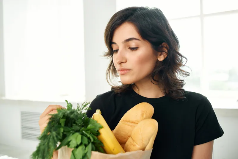 Женщина на кухне с пакетом продуктов, приготовление еды, доставка продуктов, здоровье