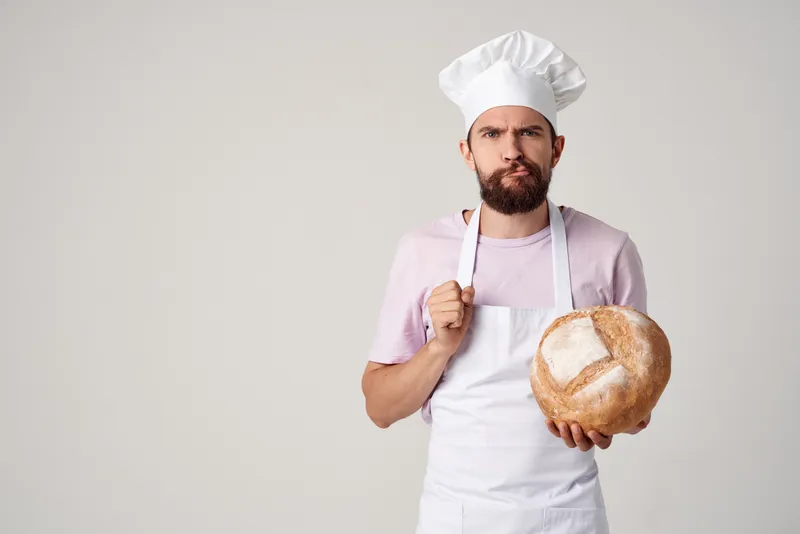 Мужчина в одежде повара, пекарь, работа с мукой и продуктами