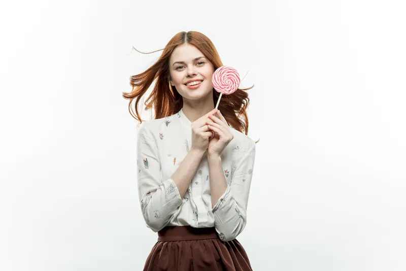 Рыжеволосая женщина с леденцом в руках, эмоции, веселье, сладости, образ жизни