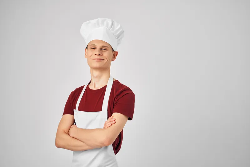 Повар-мужчина в белом фартуке на кухне, профессионал