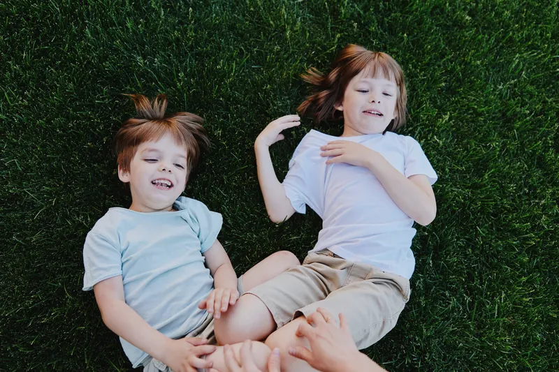 Happy children playing on green grass, enjoying a sunny day outdoors with laughter and joy. A perfect moment capturing childhood innocence and friendship.