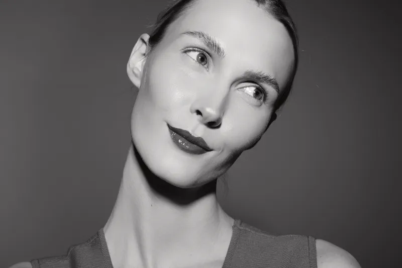 Portrait of a young white woman with pale skin and sleek hair looking sideways in studio. Concept of beauty and elegance.