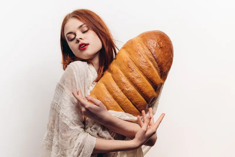 Красивая женщина обнимает батон руками, макияж, прозрачная ткань на плечах