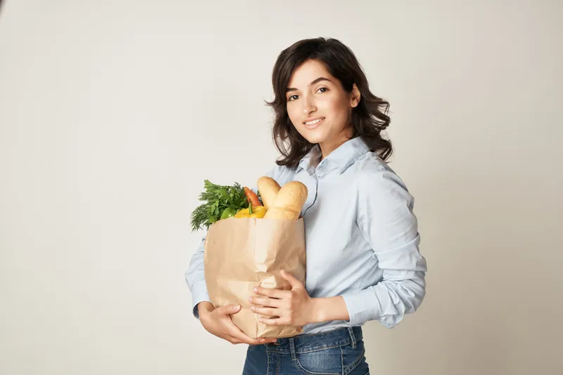 Милый брюнетка с пакетом продуктов из супермаркета, доставка еды