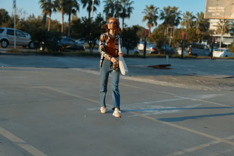 woman parking sunlight sunglasses casual walking urban golden hour scene with authenticity and candid lifestyle mood, mindful living and emotional storytelling in a modern city portrait