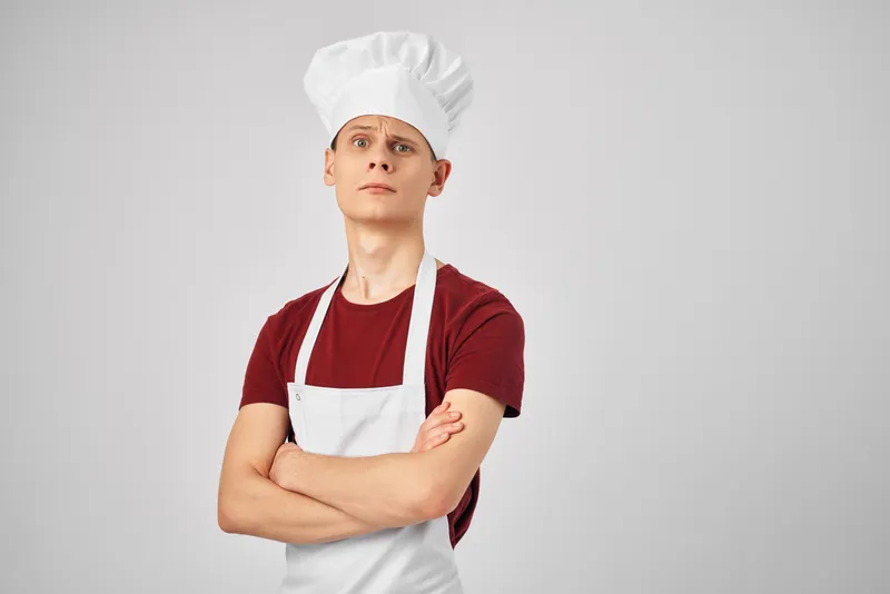 Шеф-повар держит в руке сковороду