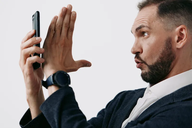 A business man professional with emotions, on an isolated colored background, delivering a confident gesture while using a mobile phone, portraying strategic focus and leadership.