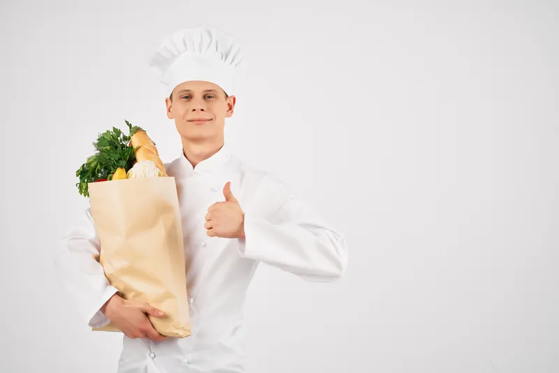 Мужчина в униформе повара с пакетом продуктов для доставки