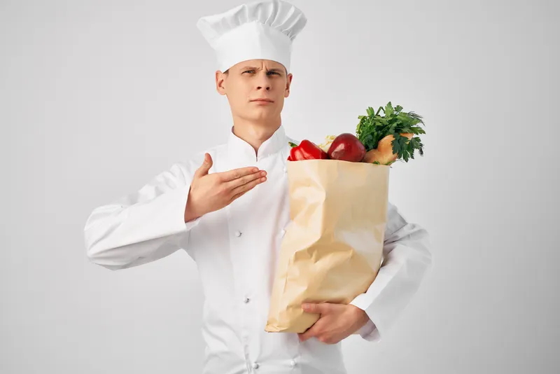 Мужчина с пакетом продуктов осуществляет доставку в рестораны