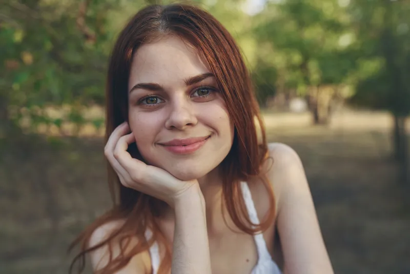 Крупный план женщины в белом платье с виноградом в руке