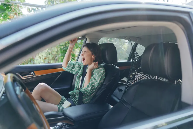 Car, driver, woman, smile a cheerful woman sits in the driver's seat with a relaxed posture and joyful expression, ready for a journey as sunlight lights the interior.