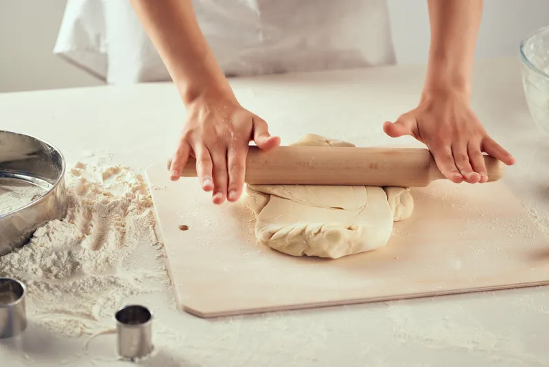 Раскатывание теста на столе, работа с мукой и продуктами на кухне