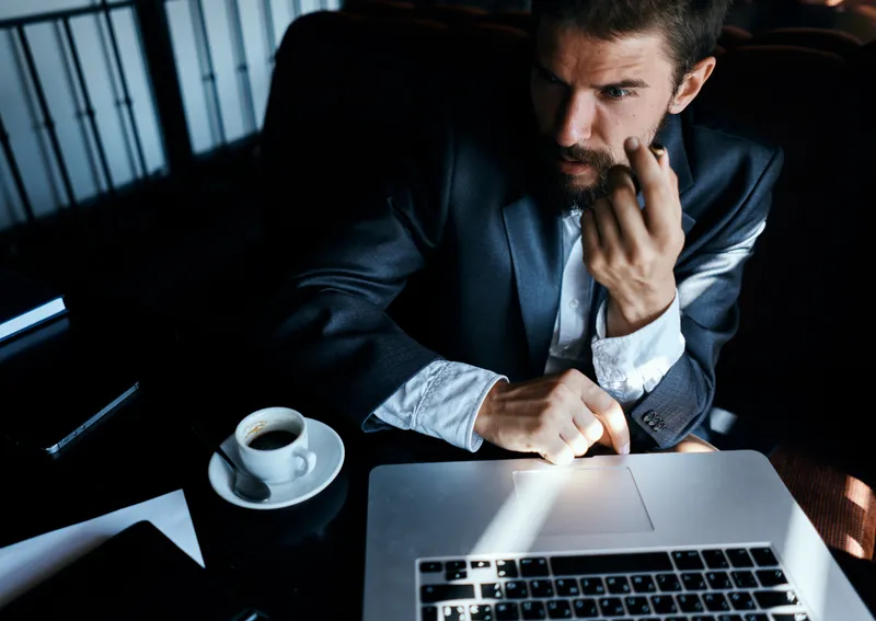 Бизнесмен работает за ноутбуком в кафе, как в офисе