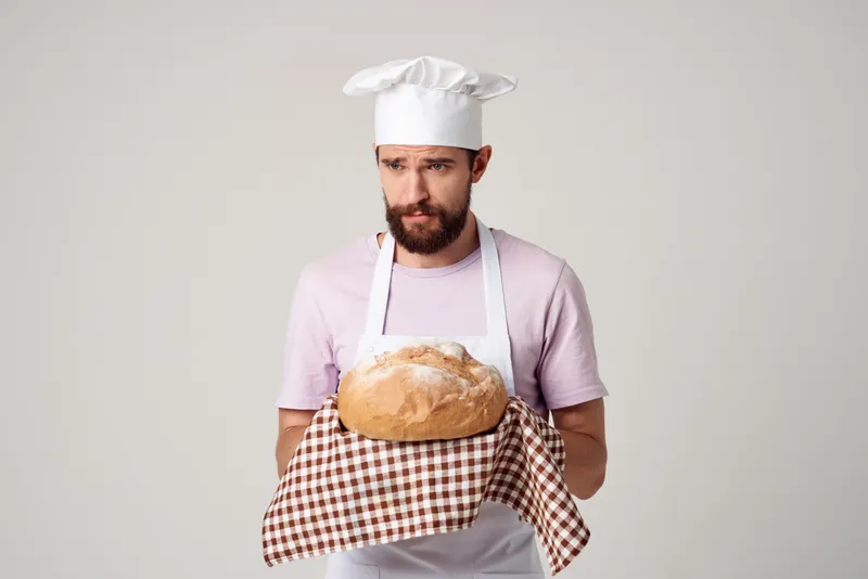 Мужчина в белом фартуке занимается изысканной кулинарией и выпечкой в ресторане