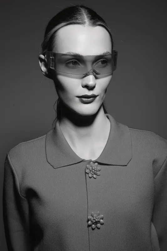 Portrait of a fair skinned caucasian woman wearing futuristic glasses and a textured sweater in a studio with dramatic lighting. Concept for fashion and modern style.
