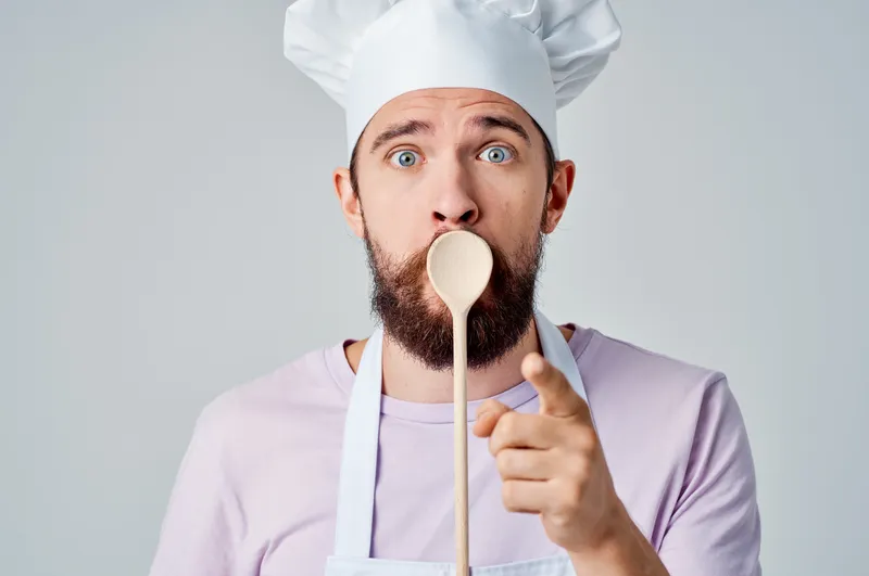 Эмоциональный повар готовит на кухне, работа и обслуживание