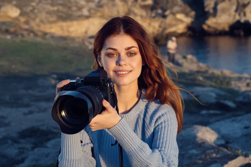Симпатичная женщина-фотограф на природе в скалистых горах, приключение