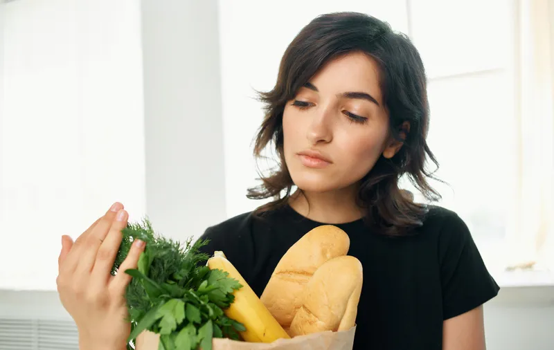 Брюнетка в черной футболке с пакетом продуктов, покупки здоровой еды