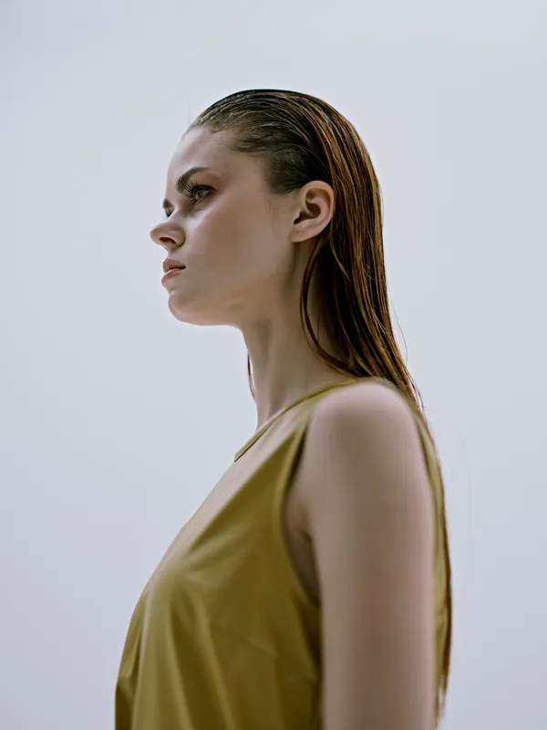 Симпатичная женщина с мокрыми волосами позирует, бросив взгляд в сторону