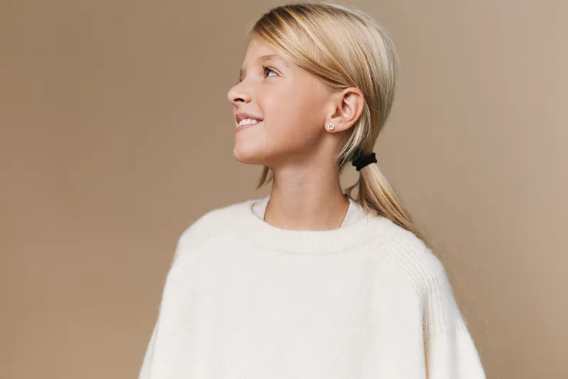 Authentic portrait of a young student in a cozy sweater, capturing a simple school lifestyle moment with calm, natural expression and casual, wholesome charm.